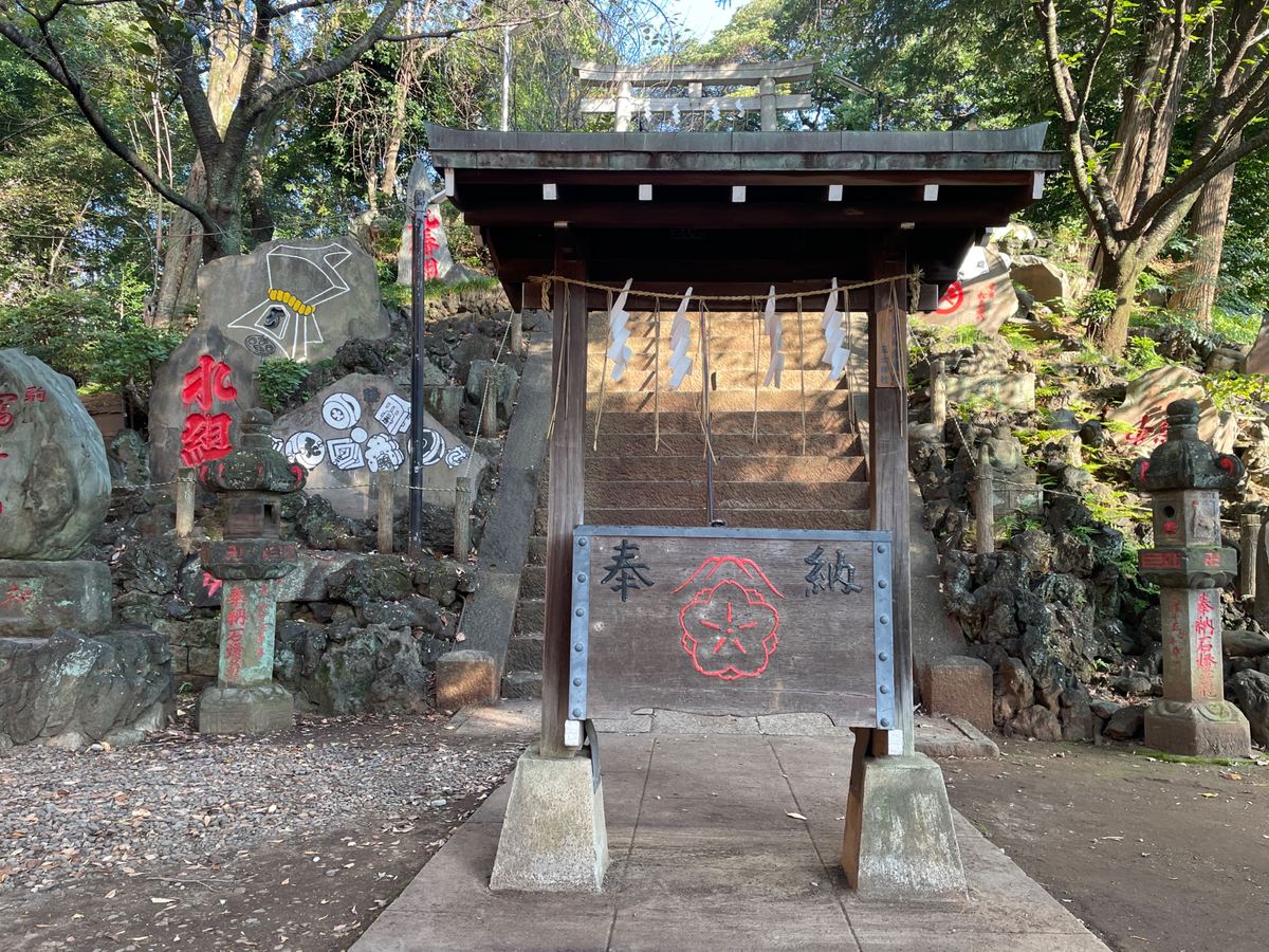 富士塚の登り口。両側の岩には、富士講の印や赤い文字が刻まれている
